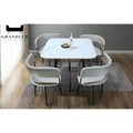 Square white stone-patterned dining table with four pale chairs