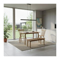 Wood dining table with bench and spindle-back chairs beside a window