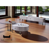 Grey TV console and oval coffee table beside a window