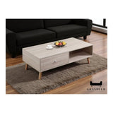 Light wood-look coffee table with drawer and open shelf beside a sofa