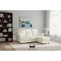 Ivory faux leather sofa and ottoman in a living room