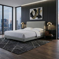 Grey Orlena bed with tapered legs in a bedroom at dusk