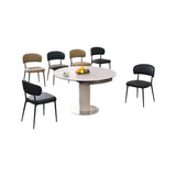 Round white pedestal dining table with black and brown chairs