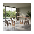 Stone-patterned dining table and upholstered chairs beside a window