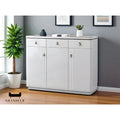 Glossy white shoe cabinet beside a plant in a living room