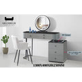 Grey vanity with black top, round illuminated mirror and side drawer unit labelled with a phone charging area