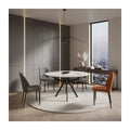 Round white dining table with contrasting chairs in a dining room