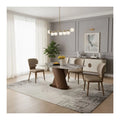 Grey stone-patterned dining table and beige chairs beside a window