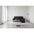 Black sofa and ottoman, front view in a living room