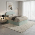 Mint upholstered storage bed beside a window