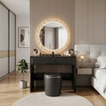 Black Vivienne vanity desk with illuminated mirror beside a bed