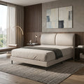 Beige upholstered bed beside a window, angled view
