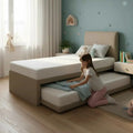 Person pulling out a trundle beneath beige Seren guest bed